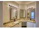 Bright bathroom featuring double sinks with granite counters and decorative framed mirrors at 3107 Woodland Ln, Alpharetta, GA 30009