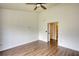 This spacious bedroom features a ceiling fan and hardwood floors, with doorway to another room at 3107 Woodland Ln, Alpharetta, GA 30009