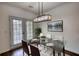 Modern dining room with a glass table, stylish lighting, and access to the outdoor area at 3107 Woodland Ln, Alpharetta, GA 30009