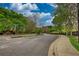 Street view of community entrance sign with flower beds and mature trees at 3107 Woodland Ln, Alpharetta, GA 30009