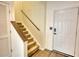 Inviting entryway featuring carpeted stairs with wooden banister and a white front door at 3107 Woodland Ln, Alpharetta, GA 30009