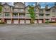 Multi-level condo/townhome building with individual garages and neutral colored siding at 3107 Woodland Ln, Alpharetta, GA 30009