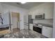 Bright kitchen features black marbled countertops, modern appliances, and convenient laundry area at 3107 Woodland Ln, Alpharetta, GA 30009