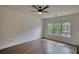 Open living space with hardwood floors, ceiling fan, and large window at 3107 Woodland Ln, Alpharetta, GA 30009