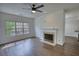 Bright living room with fireplace, ceiling fan, and hardwood floors at 3107 Woodland Ln, Alpharetta, GA 30009