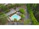 Aerial view of the community pool with an unusual shape, surrounded by lush greenery and parking at 3107 Woodland Ln, Alpharetta, GA 30009