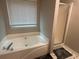 Bright bathroom featuring a white corner tub with a large window for natural light and a glass-enclosed shower at 3236 Grove Nw Trl, Acworth, GA 30101