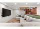 Finished basement featuring an oversized sectional, large TV, and entertainment area with modern flooring at 3607 Anna Nw Ln, Kennesaw, GA 30144