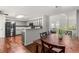 Dining area with wood floors adjoins kitchen with granite counters, stainless appliances, and an open view to the living room at 3607 Anna Nw Ln, Kennesaw, GA 30144