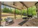 Covered brick patio with ceiling fans, chairs, grill, and a view of the backyard at 3607 Anna Nw Ln, Kennesaw, GA 30144