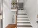Bright foyer showcases staircase with wooden steps and white risers, contrasted with dark wood handrail and iron balusters at 3607 Anna Nw Ln, Kennesaw, GA 30144
