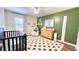Bedroom with green accent wall, crib, accent chair, and natural wood dresser at 109 Red Fox Dr, Dallas, GA 30157