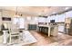 Open kitchen with island seating, stainless steel appliances, modern light fixtures, and an eat-in dining area at 109 Red Fox Dr, Dallas, GA 30157