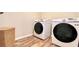 Laundry room showcasing wood-look floors, washer, dryer, and wicker storage basket at 109 Red Fox Dr, Dallas, GA 30157