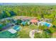 Aerial view of the community featuring tennis courts, pools, playground, and clubhouse surrounded by mature trees at 1336 Amberwood Dr, Woodstock, GA 30189