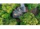 Overhead view of a home with a well-maintained roof surrounded by lush trees and a sprawling landscape at 1336 Amberwood Dr, Woodstock, GA 30189
