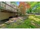 A backyard showcasing a wooden deck, terraced landscaping, and steps leading to a lush, green yard at 1336 Amberwood Dr, Woodstock, GA 30189