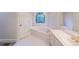 Bright bathroom featuring a jacuzzi tub with a stained glass window and a modern vanity with gold hardware at 1336 Amberwood Dr, Woodstock, GA 30189