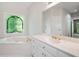 Primary bathroom featuring bright colors, white cabinets and a large soaking tub next to a stained-glass window at 1336 Amberwood Dr, Woodstock, GA 30189