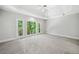 Spacious primary bedroom with a trey ceiling, neutral carpet, and large windows overlooking lush trees at 1336 Amberwood Dr, Woodstock, GA 30189