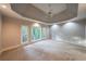 Spacious primary bedroom with a trey ceiling, neutral carpet, and large windows overlooking lush trees at 1336 Amberwood Dr, Woodstock, GA 30189
