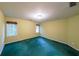 Spacious bedroom with yellow walls and green carpet, illuminated by natural light at 1336 Amberwood Dr, Woodstock, GA 30189