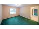 A naturally lit bedroom with green carpet and a doorway to another room at 1336 Amberwood Dr, Woodstock, GA 30189