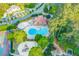 Aerial view of a community pool with a unique shape, surrounded by trees, a playground, and a clubhouse at 1336 Amberwood Dr, Woodstock, GA 30189