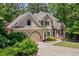 Beautiful exterior of home featuring an arched entry and side-facing garage with well-maintained landscaping at 1336 Amberwood Dr, Woodstock, GA 30189