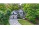 Inviting exterior surrounded by mature trees, featuring a well-manicured lawn and two-car garage at 1336 Amberwood Dr, Woodstock, GA 30189