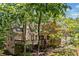 Charming two-story home featuring a spacious deck with stairs, surrounded by lush greenery and mature trees at 1336 Amberwood Dr, Woodstock, GA 30189