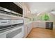 Bright kitchen featuring wood floors, white cabinets, stainless steel appliances and a large arched window at 1336 Amberwood Dr, Woodstock, GA 30189