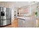 Modern kitchen with stainless steel refrigerator, white cabinets, and hardwood flooring at 1336 Amberwood Dr, Woodstock, GA 30189