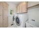 Well-equipped laundry room with washer, dryer, sink, built-in storage, and a bright window at 1336 Amberwood Dr, Woodstock, GA 30189