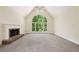 Spacious living room with fireplace and large arched window overlooking lush greenery at 1336 Amberwood Dr, Woodstock, GA 30189