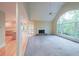 Open living room featuring a fireplace, vaulted ceiling, and a large window overlooking a lush landscape at 1336 Amberwood Dr, Woodstock, GA 30189