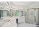 Bright primary bathroom featuring a corner shower with glass door and white double sink vanity with large mirrors at 1336 Amberwood Dr, Woodstock, GA 30189