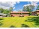 Wide shot of a large grassy backyard featuring a brick home with a wood deck and steps at 2311 Cherry Blossom Sw Dr, Atlanta, GA 30331