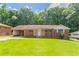 Charming brick ranch home with a well-manicured lawn and mature trees at 2311 Cherry Blossom Sw Dr, Atlanta, GA 30331