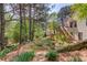 Backyard shot from slope featuring fire pit, stairway, playset and landscaping at 3095 Willow Park Dr, Dacula, GA 30019
