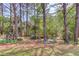 Backyard featuring mature trees, small outdoor seating, a birdhouse and landscaping at 3095 Willow Park Dr, Dacula, GA 30019