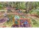 Backyard featuring a stone fire pit, seating, mature trees, and a playset with swings and slide at 3095 Willow Park Dr, Dacula, GA 30019