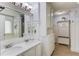Bright bathroom featuring double vanity, fresh white wainscotting, and a large mirror at 3095 Willow Park Dr, Dacula, GA 30019
