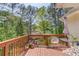Outdoor deck featuring wooden deck and railing, seating, an umbrella, and decorative plants and flowers at 3095 Willow Park Dr, Dacula, GA 30019