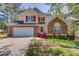 Charming two-story home with red accents, a well-manicured lawn, and a two-car garage at 3095 Willow Park Dr, Dacula, GA 30019