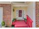 Close-up of a charming front porch with red steps and potted plants at 3095 Willow Park Dr, Dacula, GA 30019