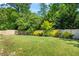 Backyard view of the large manicured lawn, wooden fence, and mature trees at 450 Hammersmith Dr, Suwanee, GA 30024