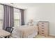 Cozy bedroom with natural light, neutral color palette, and a dresser at 450 Hammersmith Dr, Suwanee, GA 30024