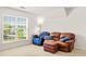 Bonus room features a large window, a loveseat and a recliner at 450 Hammersmith Dr, Suwanee, GA 30024