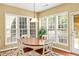 Bright breakfast nook with large windows, wood table, and seating area at 450 Hammersmith Dr, Suwanee, GA 30024